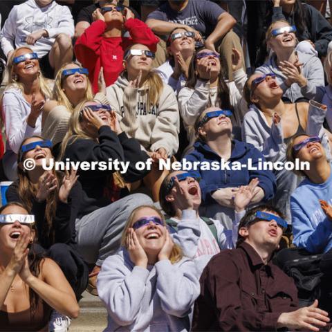 Kappa Kappa Gamma members cheer at 1:53 pm for the highest coverage of the sun. The Solar Social party to view the partial solar eclipse filled the greenspace outside the Nebraska Union on City Campus. April 8, 2024. Photo by Craig Chandler / University Communication and Marketing.