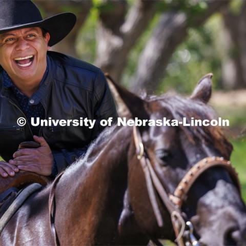 Hector Palala dismounts after receiving a ride on one of the rodeo horses. He borrowed the hat so he’d look the part as he rode. The Nebraska Rodeo Team gave Huskers a chance to be up close to their horses and even go for a ride. The team filled the space northwest of the Union to help promote their Nebraska Cornhusker College Rodeo being held Friday and Saturday. April 29, 2024. Photo by Craig Chandler / University Communication and Marketing.