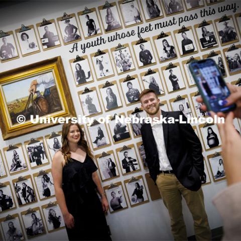 Alyssa Moser and Cole Kalkowski pose for a friend in front of their Engler portraits. The Engler Agribusiness Entrepreneur Senior Celebration and The Engler Awards night. The night became a celebration of life for donor Paul Engler, who died Friday at age 94. May 3, 2024. Photo by Craig Chandler / University Communication and Marketing.