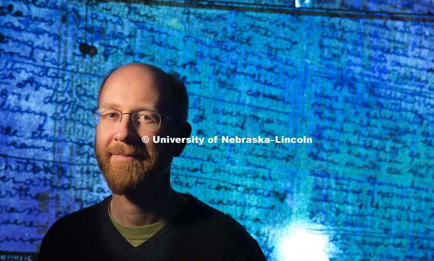 Adrian S. Wisnicki, assistant professor of English, stands in front of a projected image of Dr. David Livingstone's 1871 diaries made readable using spectral imaging technology. March 12, 2014.  Photo by Craig Chandler / University Communications  © 2014, The Board of Regents of the University of Nebraska. All rights reserved.
