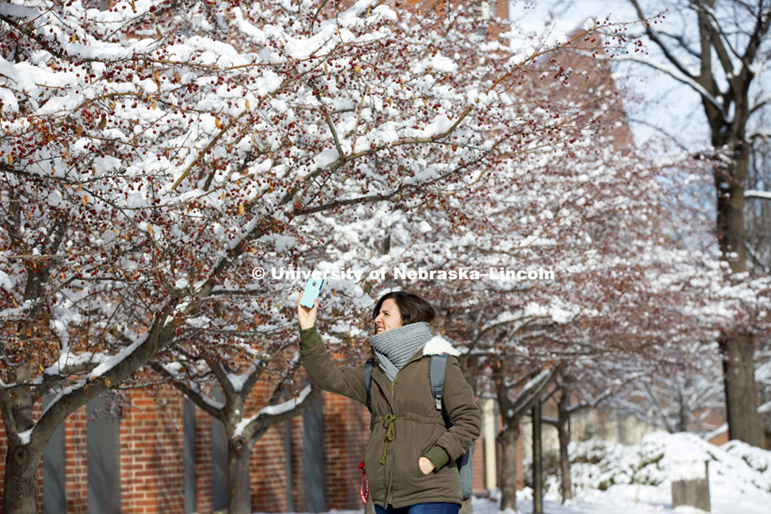 One young woman takes a picture of the snow with her phone. The UNL campus is covered by the first substantial snowfall of the year. February 3, 2015. Photo by Craig Chandler / University Communications.