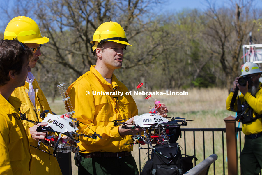 Professor Carrick Detweiler describes to the media how the drone will drop a small ball to start the burn.  The ball has a chemical powder in it and while airborne, the drone will inject a second chemical.  The drone then drops the ball and it bursts into flames within 60 seconds. UNL researchers use a small drone to set prairie burn at Homestead National Monument in Beatrice, NE. April 22, 2016. Photo by Craig Chandler / University Communications