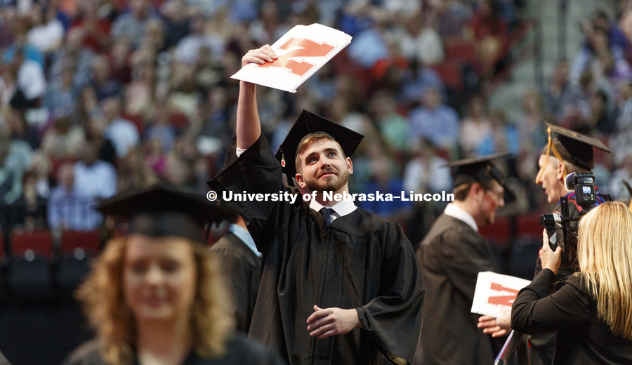 Matthew Jensby shows off his College of Arts and Sciences diploma to his family and friends in the arena. Students received their undergraduate diplomas Saturday morning in Lincoln's Pinnacle Bank Arena. 2452 degrees were awarded Saturday morning. May 6,