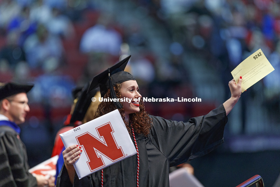 Sydney Omtvedt waves to family and friends in the arena. Students received their undergraduate diplomas Saturday morning in Lincoln's Pinnacle Bank Arena. 2452 degrees were awarded Saturday morning. May 6, 2017. Photo by Craig Chandler / University