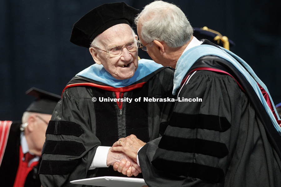 Roy Long is congratulated by Nebraska Board of Regent Chairman Robert Whitehouse after Long received an honorary Doctor of Education degree during the August Commencement at Pinnacle Bank Arena. Long is a 1947 Nebraska graduate whose college education was