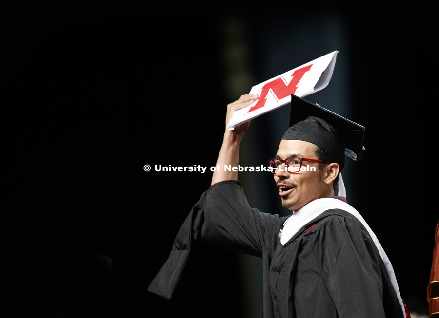 Jhonatan Munoz holds up his masters diploma Saturday. August Commencement at Pinnacle Bank Arena. August 12, 2017. Photo by Craig Chandler / University Communication.