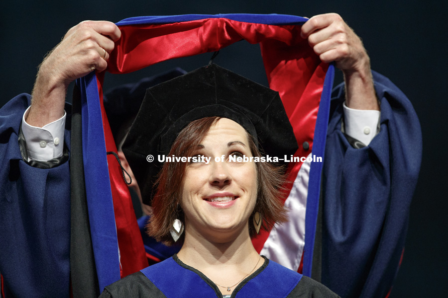 Paula Jakopovic eyes her doctoral hood as it is placed over her head. August Commencement at Pinnacle Bank Arena. August 12, 2017. Photo by Craig Chandler / University Communication.