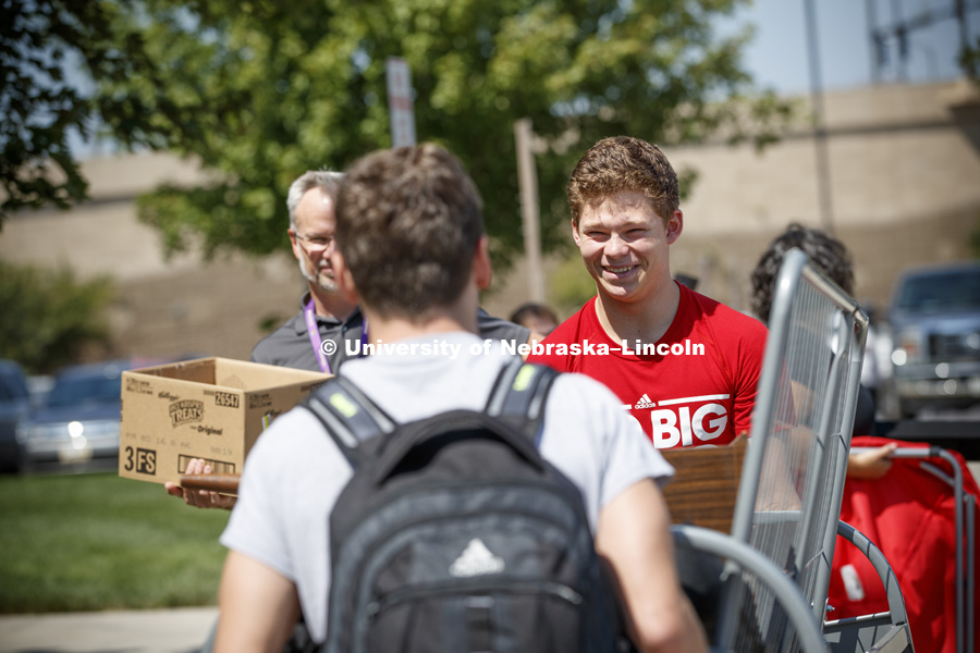 Thomas Lilly smiles as his roommate Luke Haberman walks backwards as they carry their futon into Schramm Hall. Residence Hall Move In on city campus Harper Schramm Smith Residence Halls. August 17, 2017. Photo by Craig Chandler / University Communication.