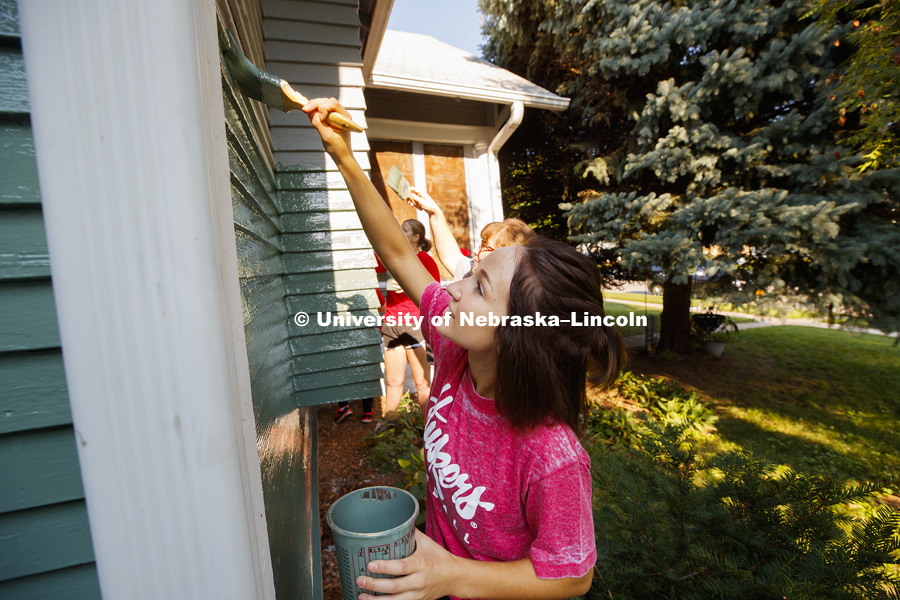 Larissa Wiebelhaus,a first-year law student from Parker, CO, paints with other University of Nebraska-Lincoln Law students and staff on a Lincoln home. The group is volunteering their time and energy in the Lincoln Paint-A-Thon. August 19, 2017. Photo by
