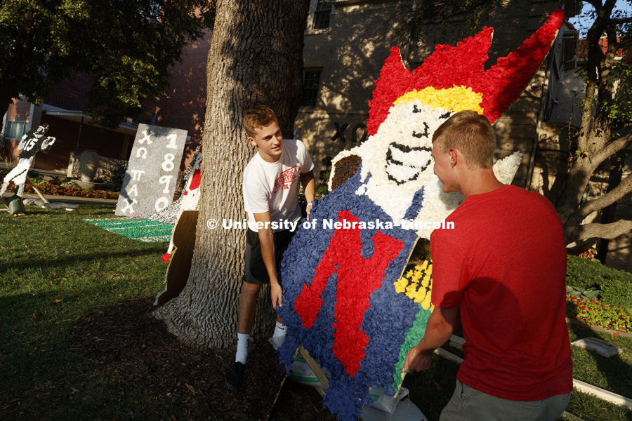 Adam Long and Chandler Brock position a pomped Herbie Husker on the display on the Chi Omega lawn. Homecoming lawn displays. September 21, 2017. Photo by Craig Chandler / University Communication.