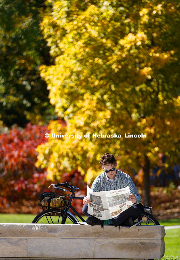 Andrew Kosmicki read the paper while enjoying the sunshine outside Adele Coryell Hall Learning Center in Love Library North. October 18, 2017. Photo by Craig Chandler / University Communication.