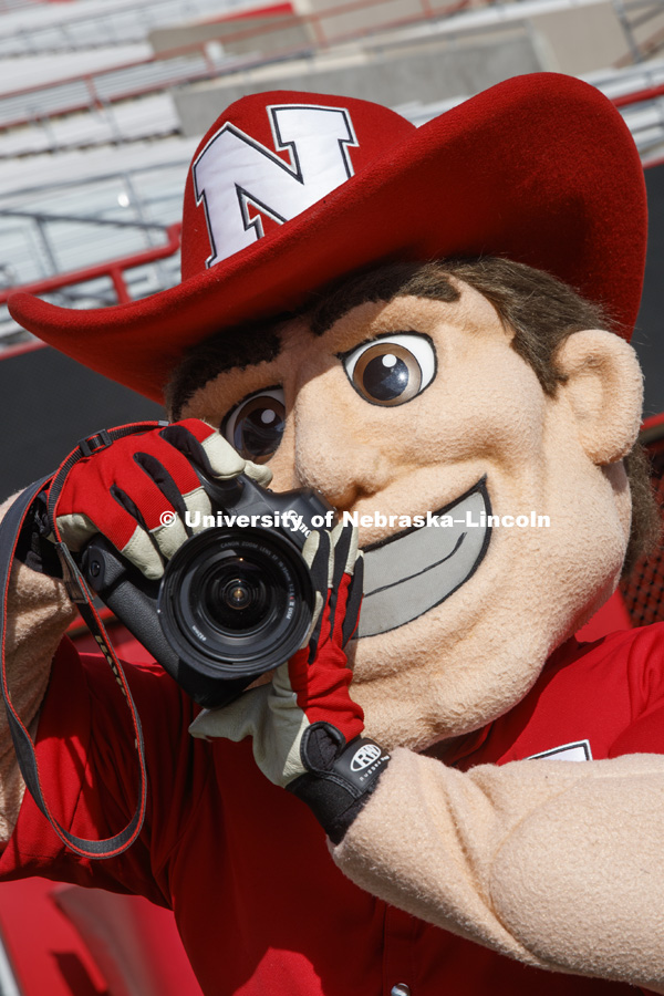 Herbie Husker takes photos during the Herbie Husker group photo with Herbie, Spirit Squad Manager Marlon Lozano, Spirit Squad Head Coach Erynn Buttzke, Alumni Director of Publications Kirstin Wilder and Director of Photography Craig Chandler. November 3,
