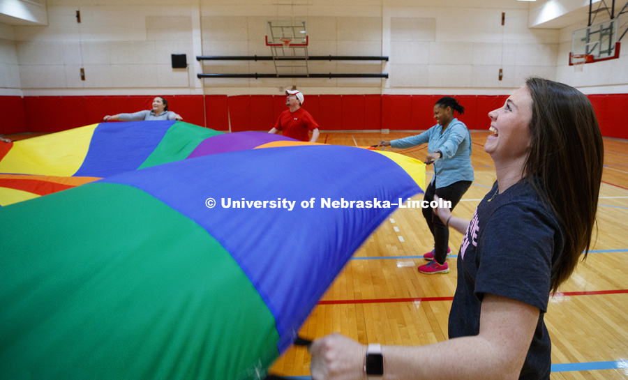 Katie Samson watches as a ball is bounced around by the student teachers using a parachute. Masters students in TEAC 893 Seminar Workshop in Health & Physical Education apply learning principals to physical education games in Mabel Lee hall gymnasium. 