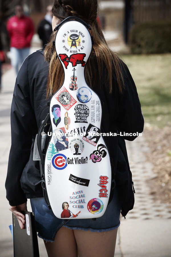 Alexandra Larson, a freshman music major from Creighton, NE, states her case for the violin as she carries her instrument across campus Friday. March 30, 2018. Photo by Craig Chandler / University Communication.