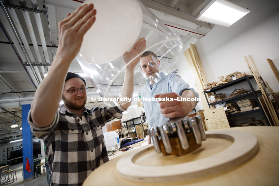 Anthropology student Steve Petty (left) and graduate research assistant Robb Nelson place a protective cover over Brakke's prototype. Museum Design students build a museum display, honoring virologist Myron Brakke and his pioneering swinging-bucket rotor for the centrifuge. April 18, 2018. Photo by Craig Chandler / University Communication.