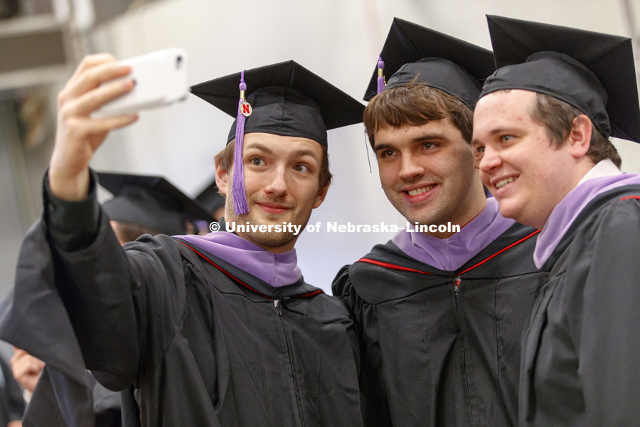 Trevor Steinkruger, Andrew Holthaus, and Adam Heyen take a selfie before Graduate Commencement at Pinnacle Bank Arena. May 4, 2018. Photo by Craig Chandler / University Communication.
