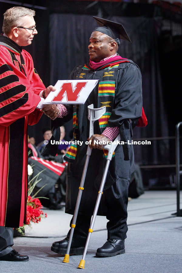 Konan Blaise Koko used crutches so he could walk across stage to receive his Masters of Science in Nutrition and Health Science from Chancellor Green. Graduate Commencement at Pinnacle Bank Arena. May 4, 2018. Photo by Craig Chandler / University