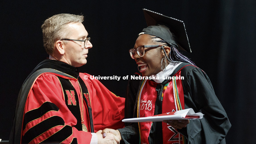 Mecca Slaughter laughs with Chancellor Ronnie Green as she receives her masters in journalism and mass communication degree. Graduate Commencement at Pinnacle Bank Arena. May 4, 2018. Photo by Craig Chandler / University Communication.