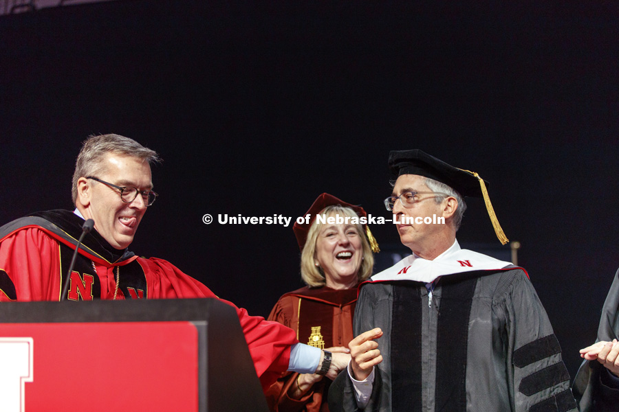 Alexander Payne is hooded as part of his honorary doctorate degree.  Behind him is Executive Vice Chancellor Donde Plowman and in front is University of Nebraska Regent Tim Claire. Undergraduate Commencement at Pinnacle Bank Arena. May 5, 2018. Photo by