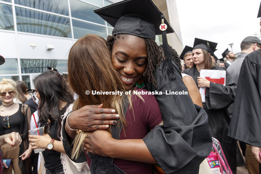 Jasmine Cincore is hugged by friends outside Pinnacle Bank Arena following commencement. Undergraduate Commencement at Pinnacle Bank Arena. May 5, 2018. Photo by Craig Chandler / University Communication.