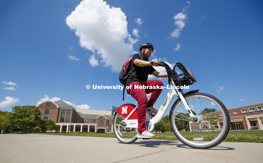 Achintya Handa uses the BikeLNK system to demonstrate the bicycle on campus. July 31, 2018. Photo by Craig Chandler / University Communication.