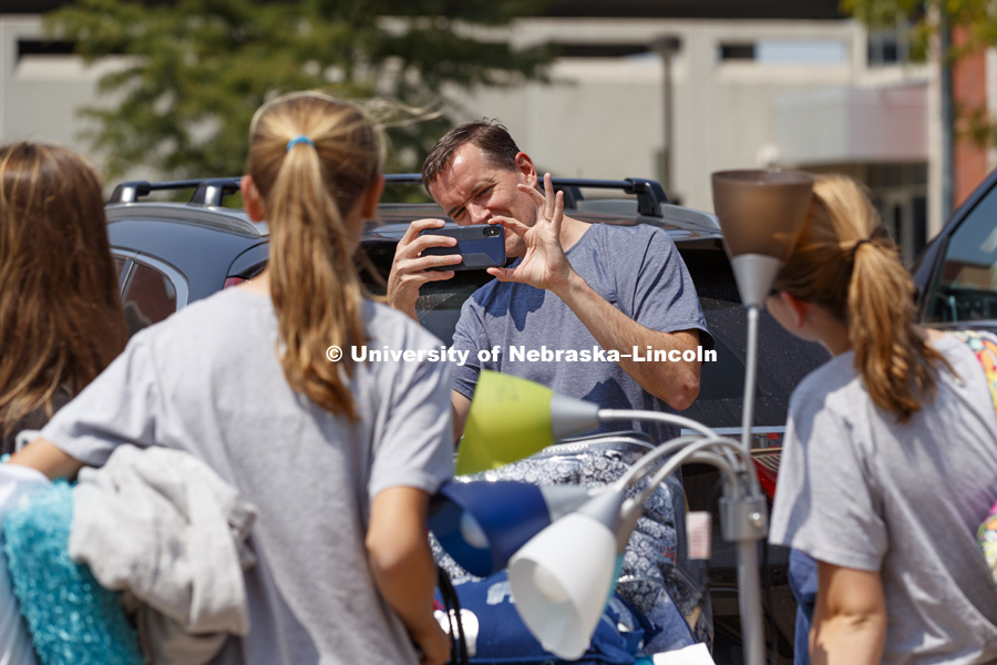 Mike Zimmerman from Liberty, Missouri, takes a photo of daughters including new freshman Emily Zimmerman who was moving into Smith Hall at the start of sorority rush week. August 12, 2018. Photo by Craig Chandler / University Communication.