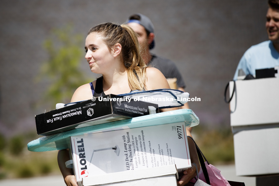 Tessa Kurtenbach helps carry in furnishings for her future sister-in-law. Housing move in for sorority rush week. August 12, 2018. Photo by Craig Chandler / University Communication.
