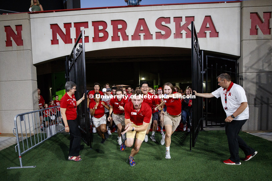 Ronnie and Jane Green open the gates as the New Student Enrollment leaders rush the field leading the new students out. Tunnel walk for incoming students. August 17, 2018. Photo by Craig Chandler / University Communication.
