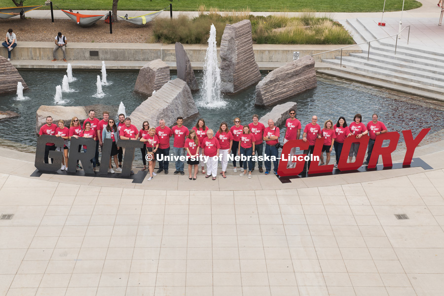 The University Communication group poses for a picture in front of the Broyhill Fountain by the Grit and Glory signs. In Our Grit, Our Glory brand reveal party on city campus at the Nebraska Union. August 30, 2018. Photo by Greg Nathan, University Communication.