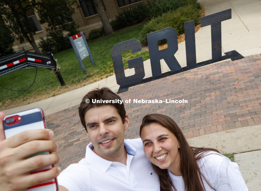 Felipe Ribeiro and Thais Ribeiro take a selfie in front of the Grit stand out. In Our Grit, Our Glory brand reveal party on east campus at the Nebraska Union. August 31, 2018. Photo by Craig Chandler / University Communication.