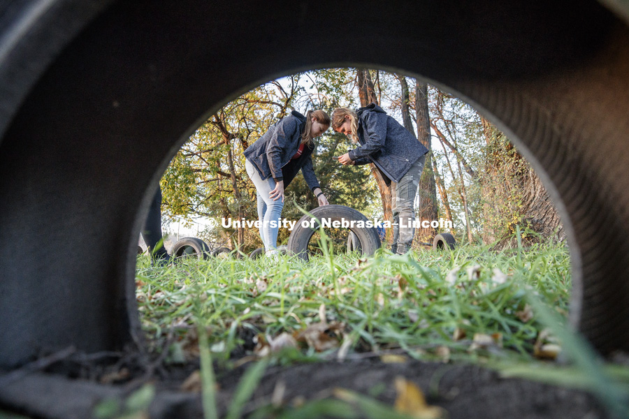Amy Douglas of Kansas City and Taylor Pitzer of Omaha photograph a scale on tire treads as part of collecting evidence. FORS 400 Crime Scene Investigation. Forensics class works at the site of an old house on the north side of east campus. October 22, 2018. Photo by Craig Chandler / University Communication.