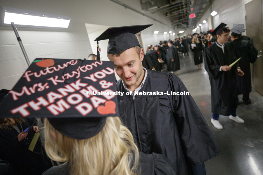 Thomas Kayton and Lynsey Coufal adjust their mortarboards before commencement. The two graduates will marry in May. Undergraduate Commencement in Pinnacle Bank Arena. December, 15, 2018. Photo by Craig Chandler / University Communication.