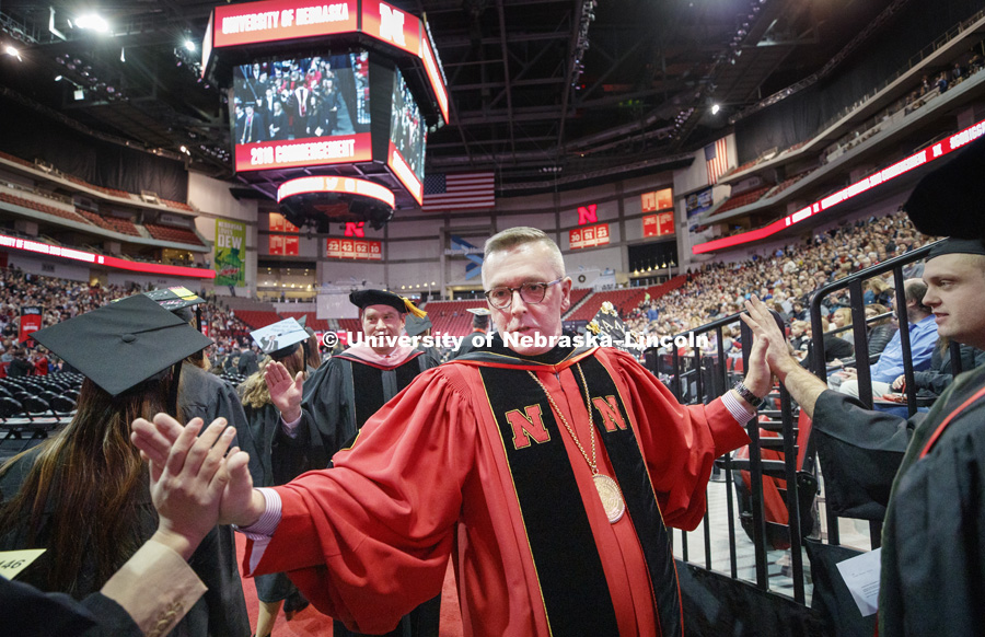Chancellor Ronnie Green and Kevin Hanrahan give high-fives to the undergrads as they enter the arena floor Saturday morning before the Undergraduate Commencement in Pinnacle Bank Arena. December 15, 2018. Photo by Craig Chandler / University Communication.