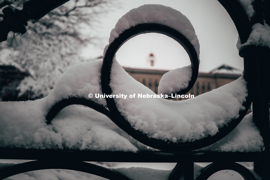 Curves in fence are covered in snow focus on the cupola of Love Library. January 12, 2019. Photo by Justin Mohling, University Communication.