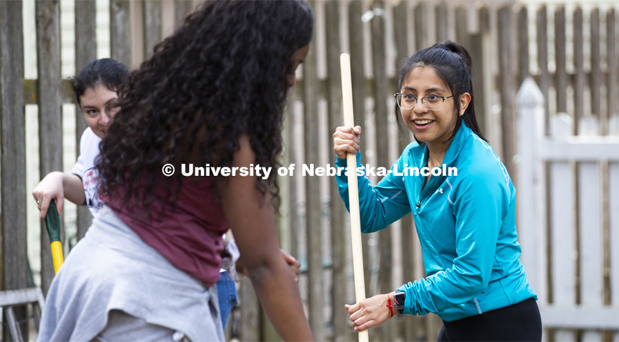 Selene Ramirez smiles as she talks with Olivia Mambo while raking a yard. She and others in the Minority Pre-Health Association painted a shed and cleaned up a yard at their job site. More than 2,500 University of Nebraska–Lincoln students, faculty and staff volunteered for the Big Event on April 6, completing service projects across the community. Now in its 13th year at Nebraska, the Big Event has grown to be the university's single largest student-run community service project. April 6, 2019. Photo by Craig Chandler / University Communication.