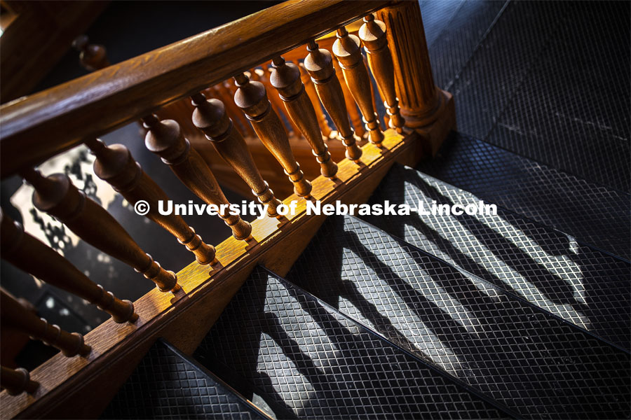 The sun shines through the bannister in the stairwell at Architecture Hall on City Campus. April 26, 2019. Photo by Craig Chandler / University Communication.