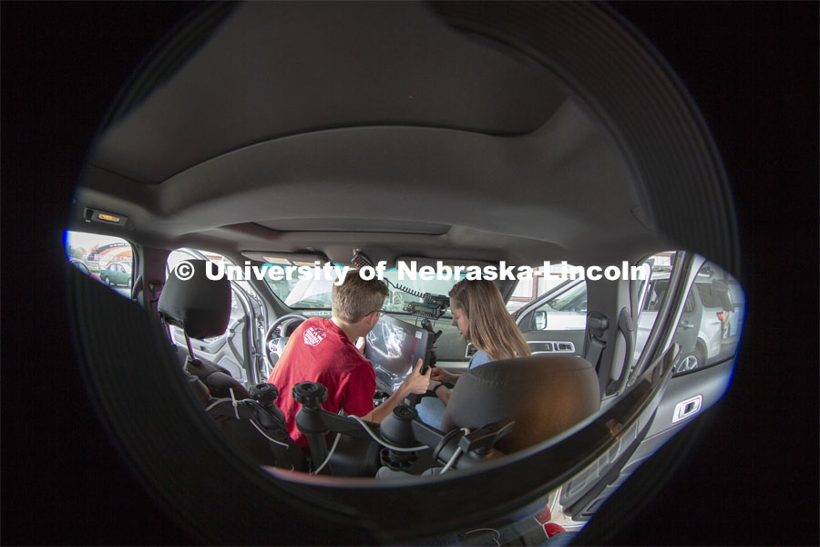 Nebraska students (from left) Brennan Darrah and Maddy Diedrichsen install a new computer screen inside a storm chase vehicle. Each of the research vehicles include three computer stations — two in the back seats and one in the front. Along with collecting data, the computers are also used to track storms via radar and for navigation. April 26, 2019. Photo by Troy Fedderson / University Communication