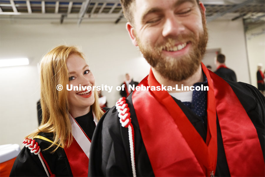 Students decked out in their graduation garb smile for the camera. Undergraduate commencement at Pinnacle Bank Arena, May 4, 2019. Photo by Craig Chandler / University Communication.