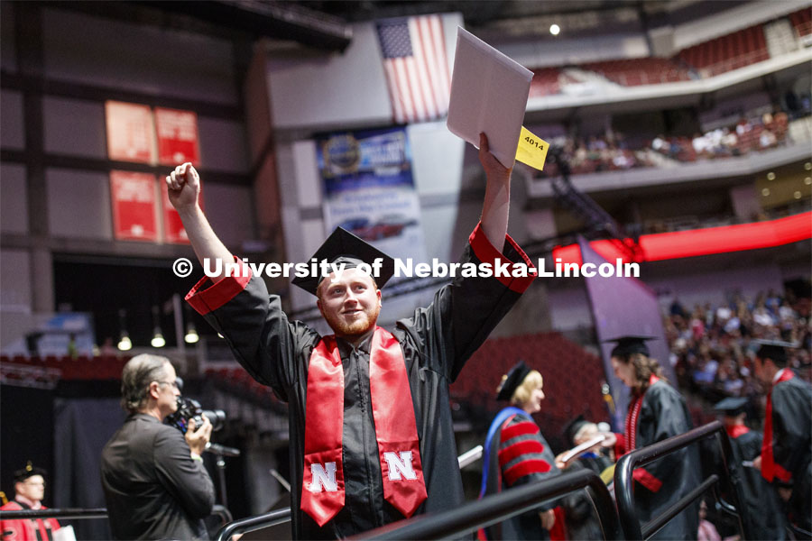 Jacob Andrews gestures to family and friends after receiving his College of Business diploma. Undergraduate commencement at Pinnacle Bank Arena, May 4, 2019. Photo by Craig Chandler / University Communication.