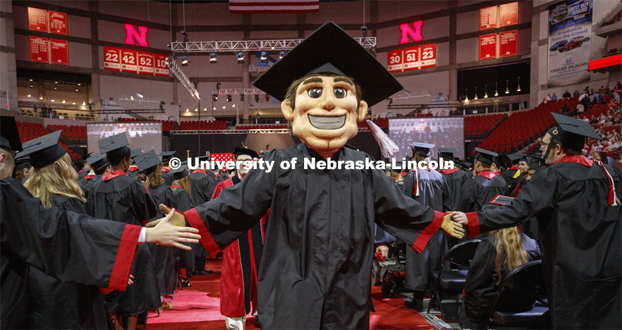 Herbie Husker, decked out in a cap and gown, leads the procession off stage Saturday morning. Undergraduate commencement at Pinnacle Bank Arena, May 4, 2019. Photo by Craig Chandler / University Communication.