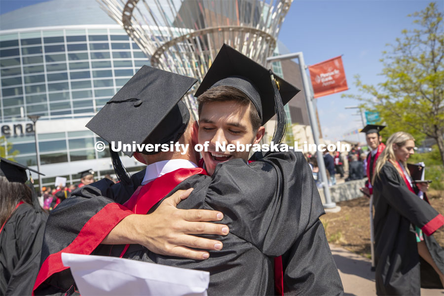 Matt Brugger congratulates a friend after commencement. Undergraduate commencement at Pinnacle Bank Arena, May 4, 2019. Photo by Craig Chandler / University Communication.