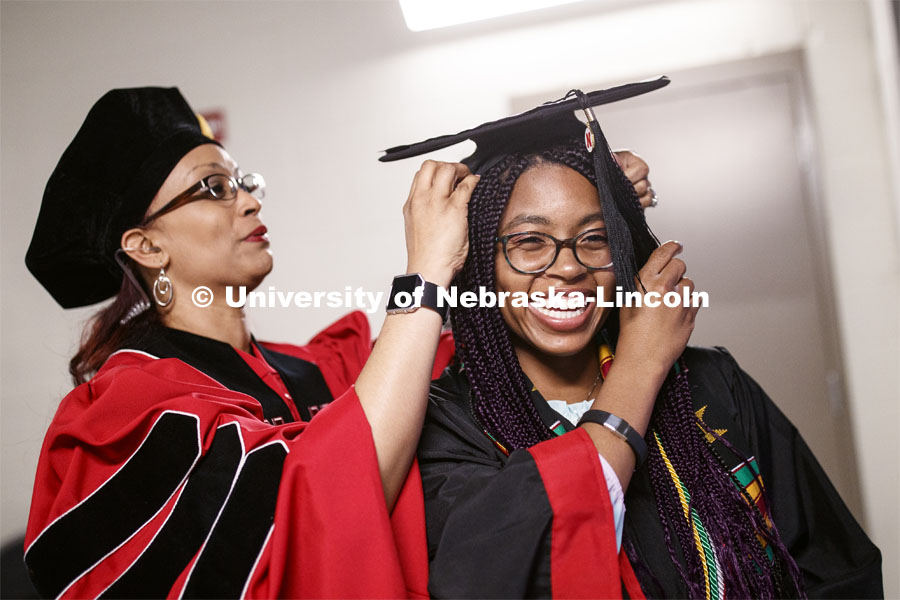 Jada Morris receives help with her mortar board from Marianna Burks before the ceremony. Undergraduate commencement at Pinnacle Bank Arena, May 4, 2019. Photo by Craig Chandler / University Communication.
