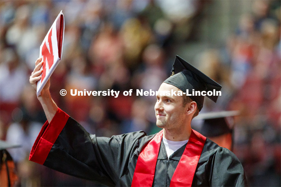 Graduate shows off his Engineering degree to family and friends Saturday afternoon. Undergraduate commencement at Pinnacle Bank Arena, May 4, 2019.  Photo by Craig Chandler / University Communication.