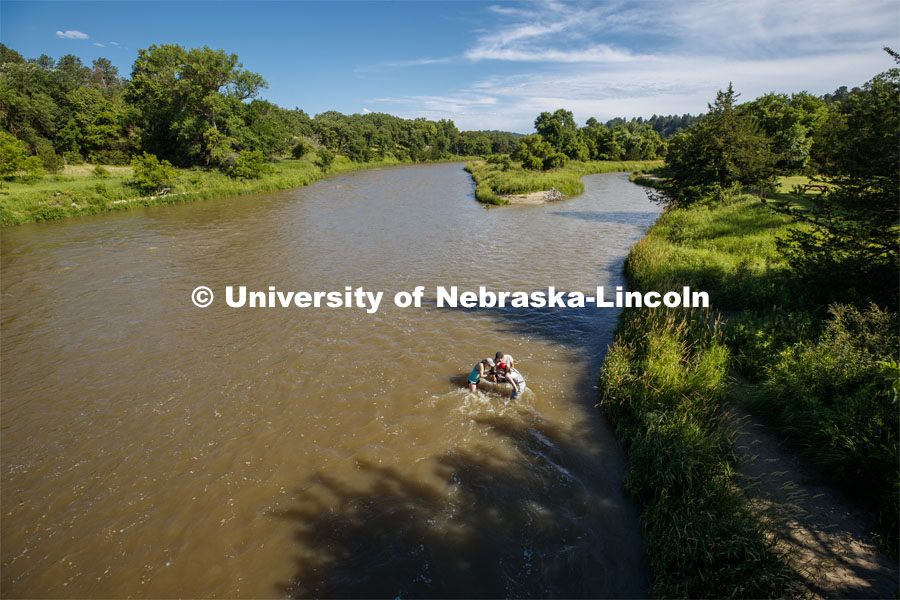 Kayla Vondracek, Jessica Corman and Matthew Chen look over a sand sample in the Niobrara River. Jessica Corman, assistant professor in the School of Natural Resources, UCARE research group researching algae in the Niobrara River. Fort Niobrara National Wildlife Refuge. July 12, 2019. Photo by Craig Chandler / University Communication.