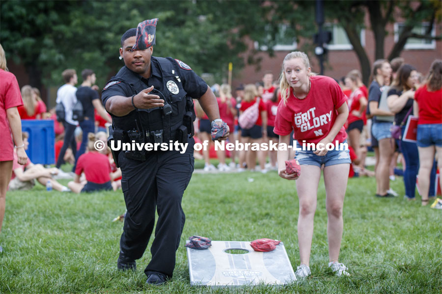 UNL Police Officer Terrell Long Jr. shows his corn hole form at the picnic. He and fellow officer Craig Tepley were challenged to a game by Hebron students McKenzie Johnson, at right, and Emily Welch. The Hebron duo won. Big Red Welcome, Chancellor's BBQ for incoming freshman and new students on the greenspace by the Memorial Union. August 23, 2019. Photo by Craig Chandler / University Communication.