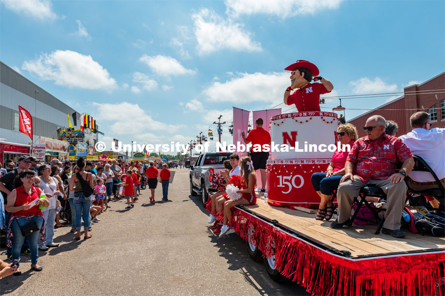 Herbie in cake parade float, flexing for kids in crows. The University of Nebraska represents and celebrates their 150th year anniversary at the Nebraska State Fair in Grand Island, Nebraska. August 1, 2019. Photo by Justin Mohling for University Communication.