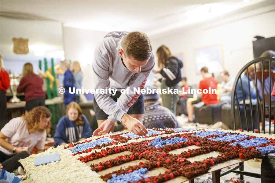 Mason Suey pomps his homecoming display. The floor of Phi Delta Theta fraternity is filled with students pomping. 2019 Homecoming display decorations. October 3, 2019. Photo by Craig Chandler / University Communication.