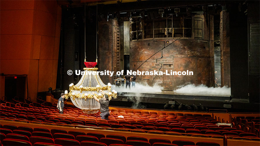 Crew members prepare the chandelier and check the fog machines for show time in the Lied Center for Performing Arts on Oct. 24. It takes 30 minutes to load the pyrotechnics needed before each performance. The chandelier has more than 6,000 crystals and 50 pyrotechnic elements to produce the five effects needed in each show. Phantom of the Opera media availability. October 24, 2019. Photo by Craig Chandler / University Communication.