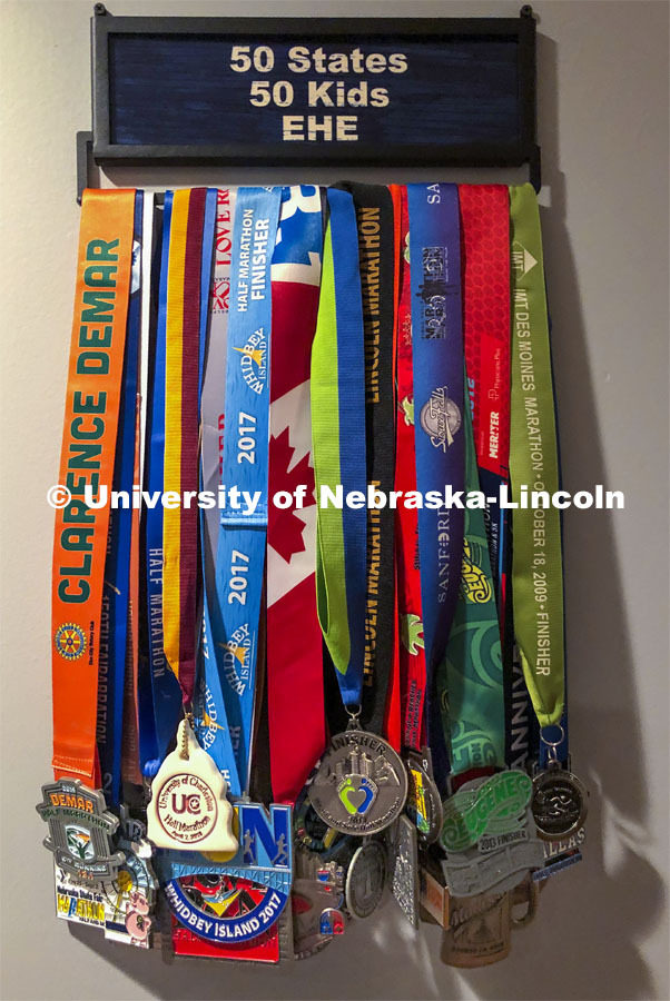 Pictured: Sue Sheridan's running medals. Sue Sheridan, director of the Nebraska Center for Research on Children, Youth, Families and Schools, is on a mission to run marathons or half-marathons in all 50 states. Sheridan is running in support of her nonprofit, Elevating Haitian Education. Sue is pictured running at Holmes Lake Park in Lincoln, Nebraska. December 4, 2019. Photo by Craig Chandler / University Communication.