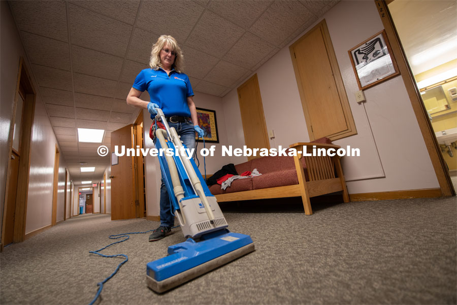 Cheryl Duncan, Residence Hall Custodial Leader, vacuums the hallway in Piper Hall. March 16, 2020. Photo by Gregory Nathan / University Communication.